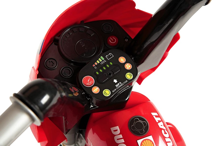 Primo piano del cruscotto della moto elettrica a 3 ruote Peg Perego Ducati Mini Evo (notare l'indicatore del livello di batteria con luci a LED, e l'ingresso per il lettore MP3)